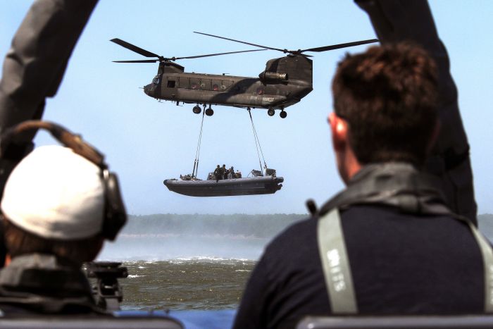 U.S. Navy Special Warfare Combatant-craft Crewmen (SWCC) on board a rigid hull inflatable boat (RHIB) observe an Army CH-47D Chinook helicopter assigned to the 159th Aviation Regiment as it lifts another RHIB during a maritime external air transportation system (MEATS) training exercise in the Virginia Capes near Fort Eustis, Virginia on 16 July 2008. MEATS trains members of SWCC on extending their operational reach by attaching special operations crafts to helicopters for transport to remote locations for further training.