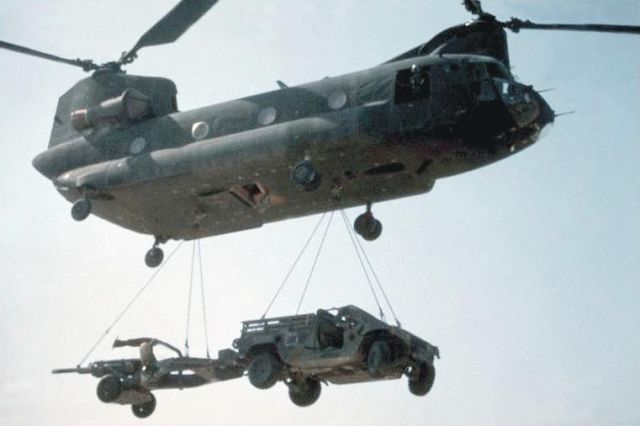 Boeing CH-47D helicopter sling loads a M198 howitzer.