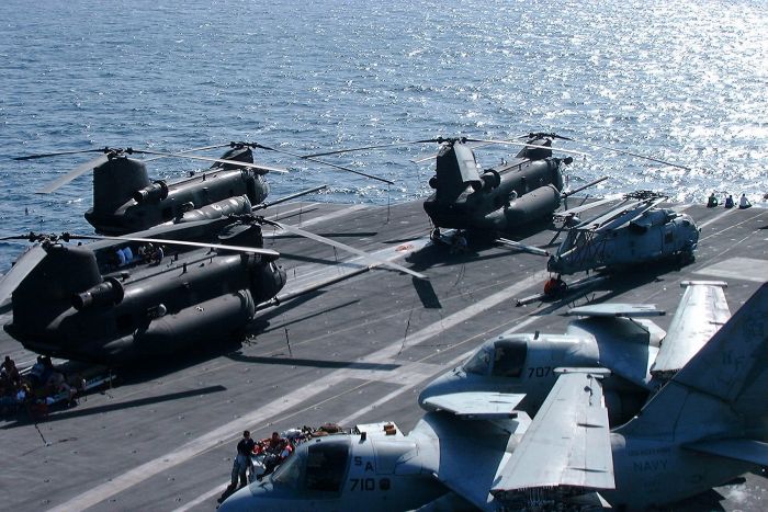 Three MH-47E Chinooks aboard an aircraft carrier enroute to a hot spot somewhere on Planet Earth.
