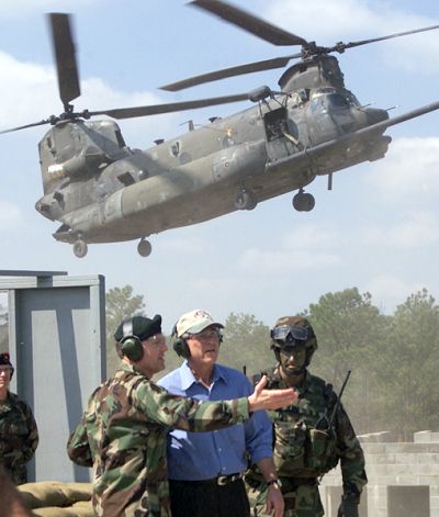President George W. Bush is joined by Lt. Gen. Doug Brown, commander of the U.S. Army Special Operations Command and Captain Peter Benchoff, 2nd Battalion, 75th Ranger Regiment, atop a building at Fort Bragg's Military Operations in Urban Terrain (MOUT) site during a Special Operations Capabilities Demonstration on 15 March 2002.