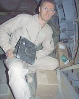 Flight Engineer, SGT Lance Reynolds holding a ramp extension pad that a bullet ricocheted off of, injuring a passenger.