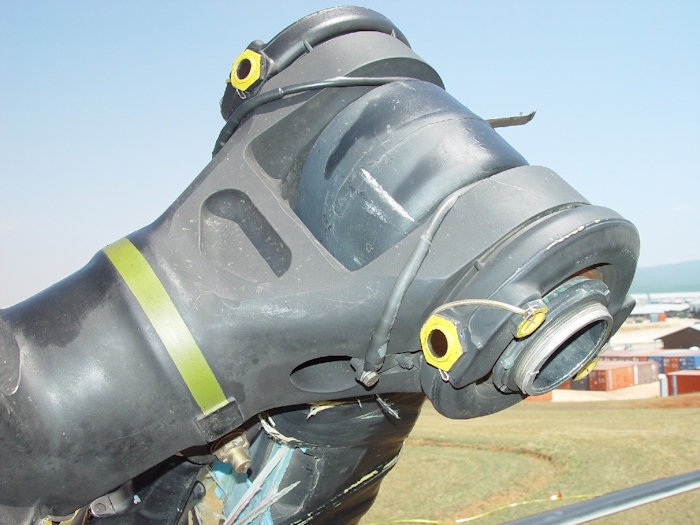 July 2002: This photograph shows extensive damage to the aft rotor system. A lead-lag dampner has broken off allowing the green blade to strike the fuselage and ground. All blades on a Chinook rotor system are color coded - Red, Green, or Yellow.  Look for the paint stripe on the rotor head - the green stripe is easily visible.