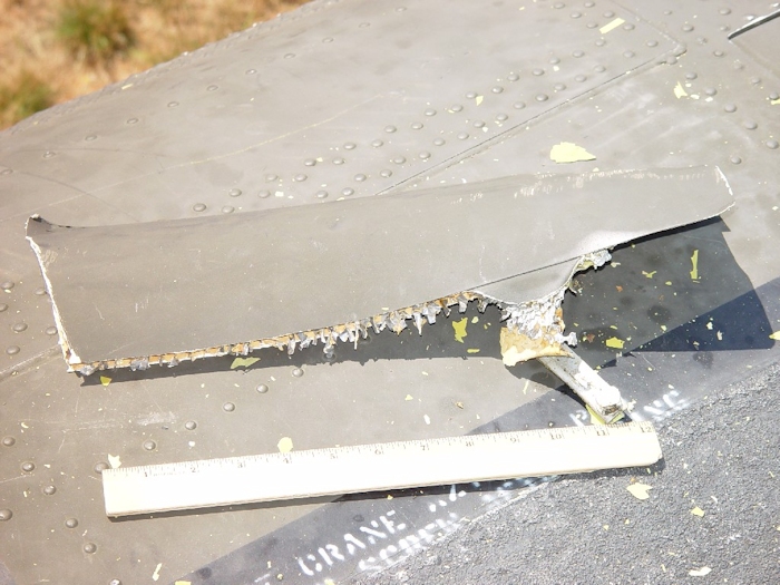 July 2002: Debris created as a result of the blade to fuselage contact was scattered around the crash site. Here a piece is found on top of the aircraft near the forward pylon above the main cabin door.