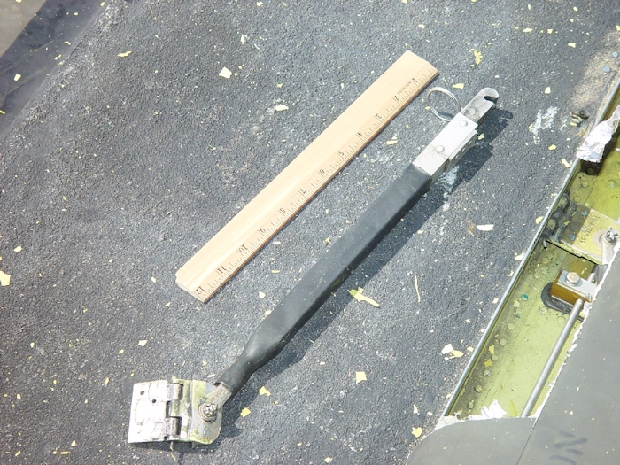 July 2002: Debris created as a result of the blade to fuselage contact was scattered around the crash site. Here half of a tunnel cover support strut is found on top of the aircraft near the forward pylon.