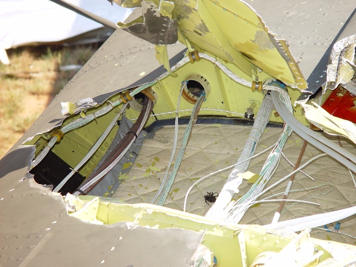 July 2002: In a close-up view of one of the damaged area, it can be seen that the fuselage skin of the Chinook helicopter, although strong, is not very thick. Some wires were cut as the blade penetrated the area and apparently, at some point, a large insect was a casualty as well.