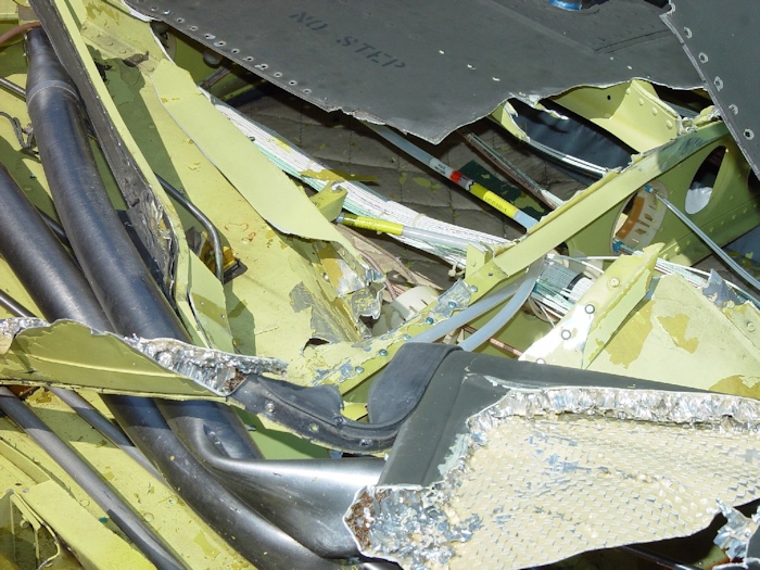 July 2002: The long shiny, silver colored items are the flight control tubes that connect to the aft pylon flight control components. Without them intact, the pilot cannot control the aircraft. Here they are seen severely damaged.
