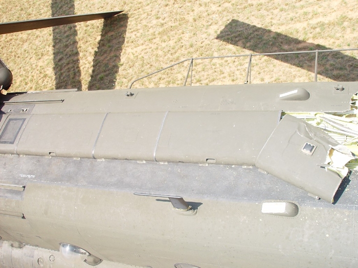 July 2002: A view down the fuselage looking aft at the tunnel covers. The towel rack looking fixture at the top right of the image is the High Frequency (HF) Radio Antenna. One can also see the aft green rotor blade in contact with the ground.