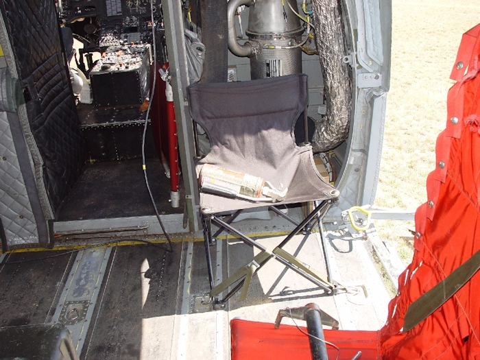 July 2002: The seat pointed out in this, and many other, accident reports over the years as being unauthorized for use by the Flight Engineer or Crew Chief. Crewmembers in the back have had to improvise and accomodate as necessary in order to crew the aircraft with as much comfort as they could muster. More often than not, there was little comfort in the main cabin area. As such, crewmembers would secure a chair to the floor best they could and did so for roughly 40 years. Finally they caught a break when PM Cargo came up with a crash survivable crew seat and it was installed in the front of the cabin on the left and right sides.