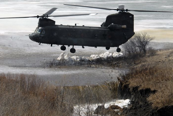15 April 2009: 92-00302, an Army National Guard CH-47D Chinook helicopter, drops several one-ton sandbags on the spill-way of the Clausen Springs Dam near Kathryn, North Dakota. The one-ton sandbags are being lowered and positioned into a place on the dam spillway so that they will divert over-flowing water away from an eroding area of the dam, caused by high water levels.