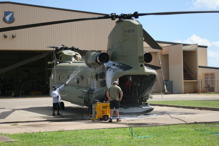 1 February 2011: CH-47F Chinook helicopter 07-08738 receives an engine wash at Wheeler Army Airfield (PHHI), Oahu, Hawaii. Solvent, used to remove oil and dirt deposits from the inside of the engine, is pumped in via an engine wash kit (yellow item on ground). Once in, the solvent is allowed to soak for approximately 20 minutes and then fresh water is flushed through the engine to remove all the contaminents. Upon completion, the engines are operated to dry out the internal portion of the powerplant. The fellow on the ground is rinsing the excess solvent off the side of the airframe to prevent staining of the aircraft paint.