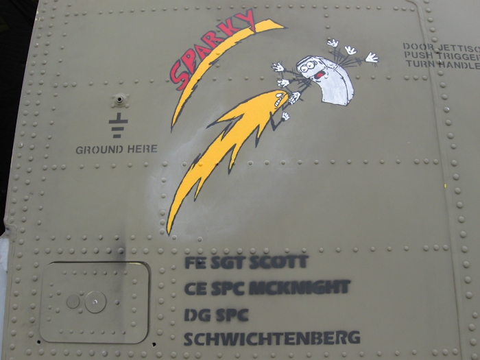 The Nose Art on 08-08056 while deployed in theater. 08-08056 had an APU Generator come off line without warning. When the crew opened the right electrical pod they discovered burnt wires and a very hot Auxiliary Power Unit (APU) Generator Control Unit (GCU). After troubleshooting it was found that the GCU was fried and the APU Generator would not operate. The burnt wires were repaired and the GCU and APU Generator were replaced. About two flights later, during a run up, there was a fire in the Number 2 Power Distribution Panel (PDP) and it all led back to the APU Generator Alternating Current (AC) electrical system. Long story short, there was a bad ground that cooked the system not once - but twice. In the nose art you see an electric bolt getting ready to strike the GCU and fry it with the GCU trying to stop it. At the top is the name of 08-08056 - 