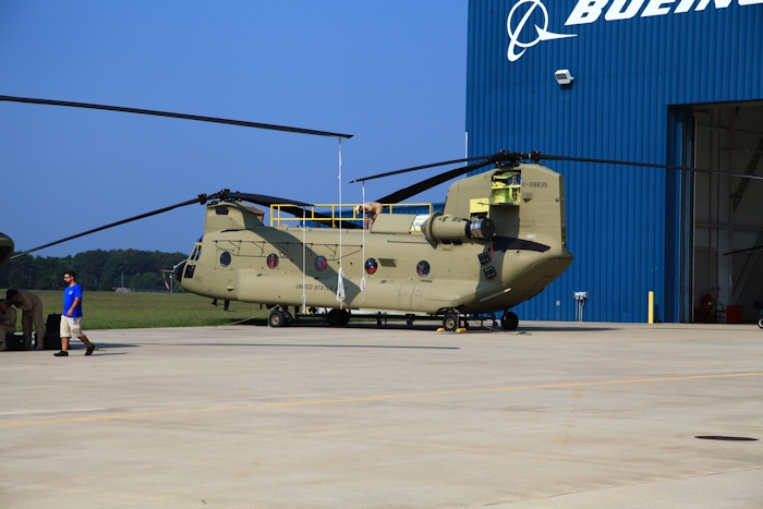 11 September 2013: CH-47F Chinook helicopter 11-08835 rests on the ramp at the Boeing Millville facility, Millville Municipal Airport (KMIV), New Jersey, awaiting movement to the Port of Baltimore for ship transport to the Republic of Korea. New Equipment Training Team (NETT) Maintenance Test Pilot Ken Lynch is opening up the top for preflight.