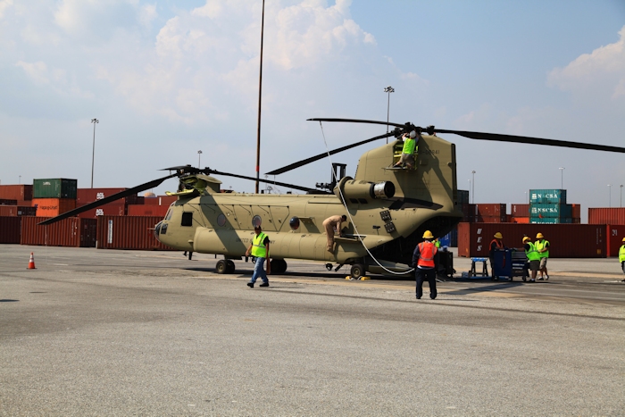 11 September 2013: CH-47F Chinook helicopter 11-08841 sits on the dock at the Port of Baltimore awaiting ship transport to the Republic of Korea. New Equipment Training Team mechanics employed by Boeing are gathering at the aircraft in preparation to remove the rotor blades and prepare the aircraft for shipboard loading.  NET Team Standardization Instructor Bill Cagle is completing the post flight inspection of the Number One Engine.