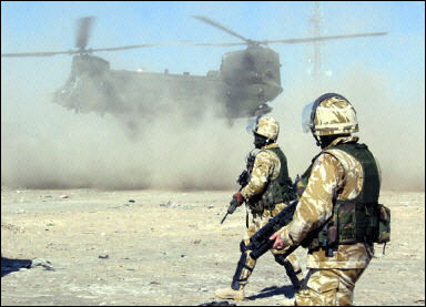 British soldiers watch as a Chinook helicopter lands in the southern Iraqi city of Basra. The British military said one of its Puma helicopters crashed there in a suspected accident, killing one airman and injuring two others.