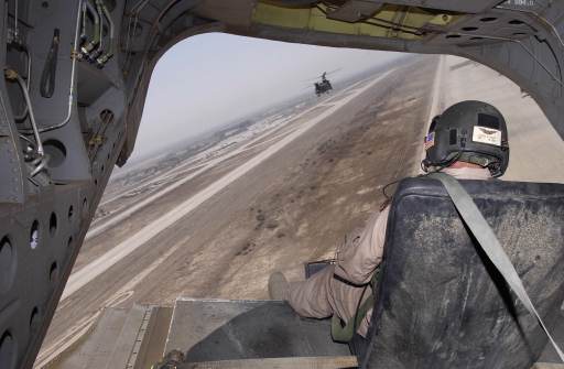 Specialist Joshua Knott, a tail gunner aboard an Army CH-47D Chinook helicopter, maintains a watchful eye during the aircraft's takeoff from Baghdad Air Base, Iraq, on Sunday, 20 July 2003.