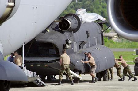 Loading a U.S. Army MH-47E Chinook helicopter aboard a U.S. Air Force C-17 transport aircraft for the return trip home.