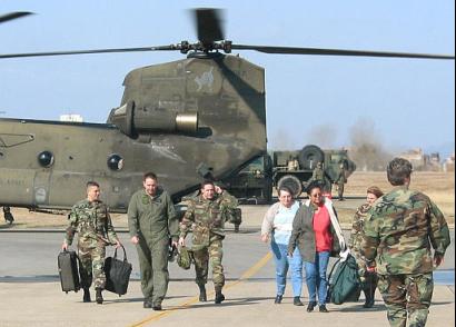 U.S. soldiers and civilians walk off a CH-47D Chinook helicopter during an evacuation drill.
