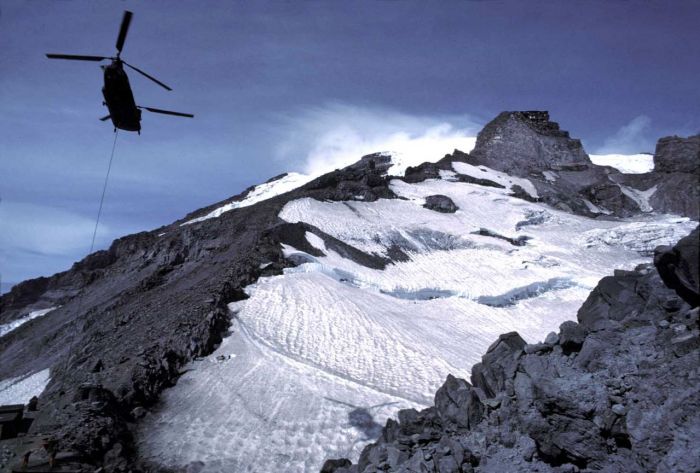 A CH-47D from the Washington Army Reserve lifts a gravel bucket to facilitate the construction of a new helipad at the 10,000 foot level Camp Muir on Mount Rainier, August 1991.