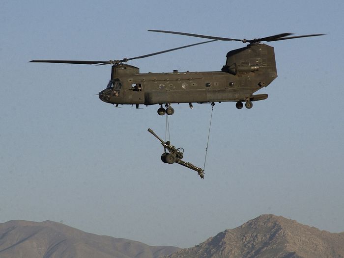 An unknown CH-47D Chinook helicopter, assigned to the "Flippers" transports an M119 105 mm Howitzer over Bagram Air Field, Afghanistan. Army aviation and artillery assets are playing a critical role in Operation Enduring Freedom and the Global War on Terrorism.